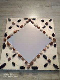 there is a square shaped mirror with rocks on it