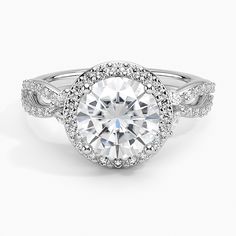 a white gold engagement ring with an oval center surrounded by round diamonds