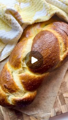 a loaf of bread sitting on top of a cutting board next to a yellow towel