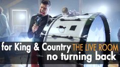 a man standing in front of a drum with the words for king & country the live room no turning back