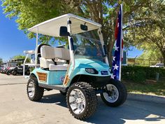 a blue golf cart parked in front of a flag