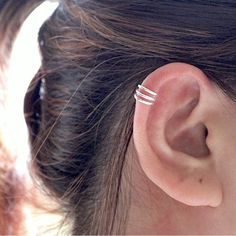 a close up of a person's ear with three thin rings on it