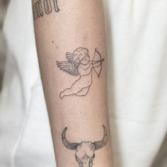 a tattoo on the arm of a person with a bull's head and angel