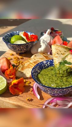 the guacamole is being served with tortilla chips and limes