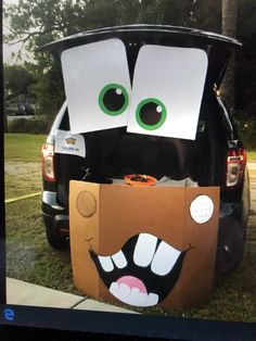 the trunk of a car is decorated with cardboard boxes and eyes