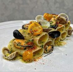 pasta with clams, oranges and other vegetables is served on a white plate