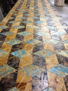 the floor is covered with blue and yellow tiles in an area that looks like it has been made out of wood