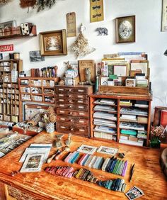 a room filled with lots of books on top of a wooden table