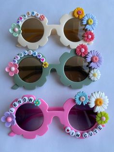 three pairs of sunglasses with flower decorations on them and the words wow to me spelled in small letters