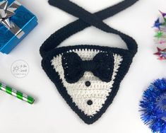 there is a crocheted triangle with a bow tie on it next to other items