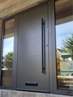 the front door to a building with two glass doors and one has a black handle on it