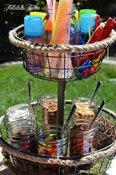 a basket filled with lots of colorful items on top of a grass covered field next to a tree