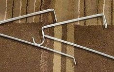 two metal clothes hangers sitting on top of a carpet