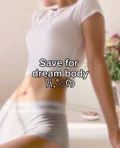 a woman in white shirt and gray shorts with words on her stomach saying save for dream body