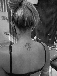 a woman with a sun tattoo on her upper back neck and behind her left shoulder