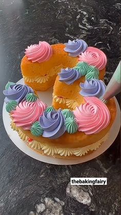 the cake is decorated with pink, blue and green icing