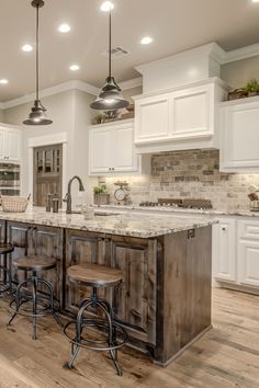 a large kitchen with white cabinets and wood flooring on the countertops, along with two bar stools