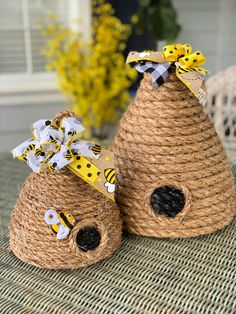 two small baskets with bees on them sitting on a table