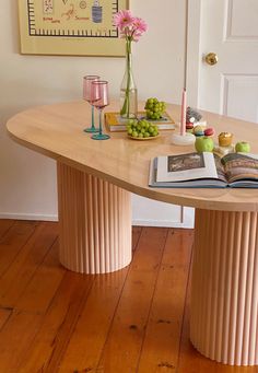 a table that has some fruit on it and a book in front of the table