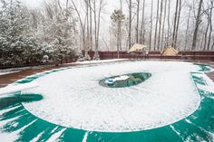 a snow covered pool surrounded by trees and bushes