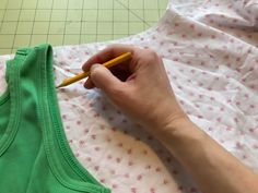 a person is cutting out clothes with a pencil