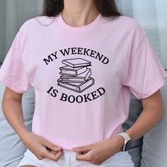 Packed with personality and perfect for the book lover, this My Weekend is Booked T-Shirt is the only way to show the world your passion for literature, and how the written page keeps you dedicated. Trust us, your weekends will never be dull again! -These classic fit t-shirts are not meant to be form-fitting, but rather offer a comfortable and relaxed style. If you prefer a more fitted look, we recommend sizing down one size. -Unisex sizing (Men and Women)-100% Cotton-The shirt brand that I use Bookish T-shirt With Funny Print, Bookish Short Sleeve T-shirt With Funny Text, Bookish T-shirt With Funny Print For School, Bookish Letter Print T-shirt For School, Bookish T-shirt With Funny Text And Crew Neck, School T-shirt With Letter Print In Bookish Style, Pink Crew Neck T-shirt With Bookish Style, Short Sleeve T-shirt With Funny Text, Not Meant To Be