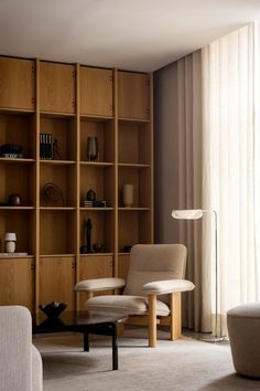 a living room filled with lots of furniture and bookshelves next to a window