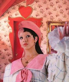 a woman wearing a pink hat and dress in front of a mirror