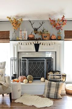 a living room filled with furniture and a fire place covered in fall decorations on top of a mantel