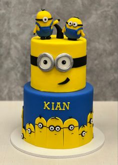 a three tiered cake decorated with minion faces