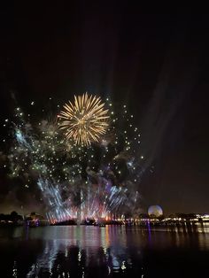 fireworks are lit up in the night sky over water