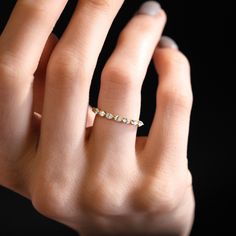 a woman's hand with a diamond ring on her left hand, black background