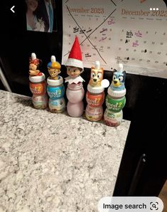 a group of baby bottles sitting on top of a counter next to a wall calendar