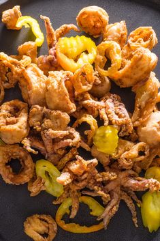 fried food on a black plate with peppers and chicken pieces in the middle, ready to be eaten