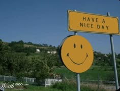 two yellow street signs sitting next to each other on top of a lush green field