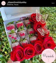 there is a box filled with red roses and chocolate covered strawberries in the shape of butterflies