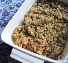 a casserole dish with meat and vegetables in it on a blue tablecloth