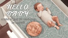 a baby laying on top of a blue rug next to a wooden plaque that says hello baby