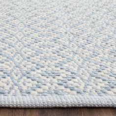 a blue and white rug on top of a wooden floor