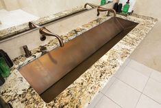 a bathroom sink sitting under a mirror next to a counter top with bottles on it