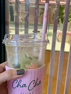 a person holding up a drink with a straw in it's cup and the words cha cha matcha next to it