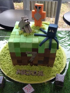 a cake made to look like a minecraft block with two small figures on top