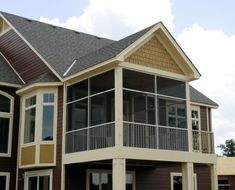 a two story house with multiple balconies on the second floor