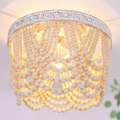 a white chandelier with beads hanging from it's ceiling and light fixture