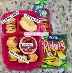 two plastic containers filled with food on top of a marble counter next to a bag of chips