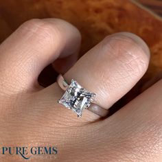 a woman's hand with a diamond ring on top of her finger and the words pure gems