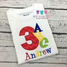 a white shirt with the number three on it and an image of a child's name