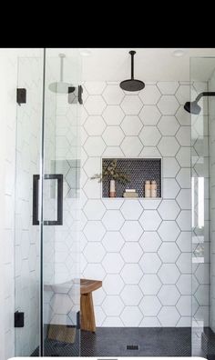 a white tiled bathroom with black and white tile