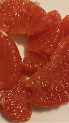 peeled grapefruits sitting on a white surface