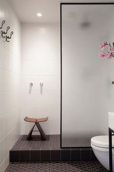 an image of a bathroom with a bench in the middle and flowers on the wall